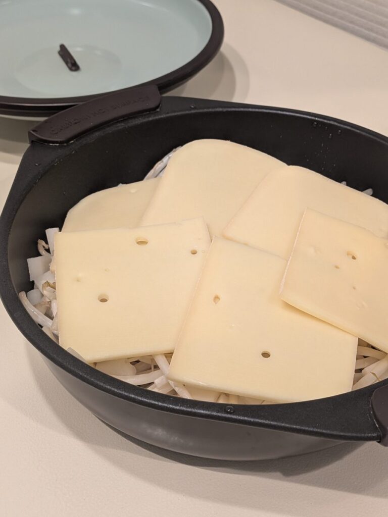 レンジグリルパンのもやしとモチの上にラクレットチーズをのせたところ
