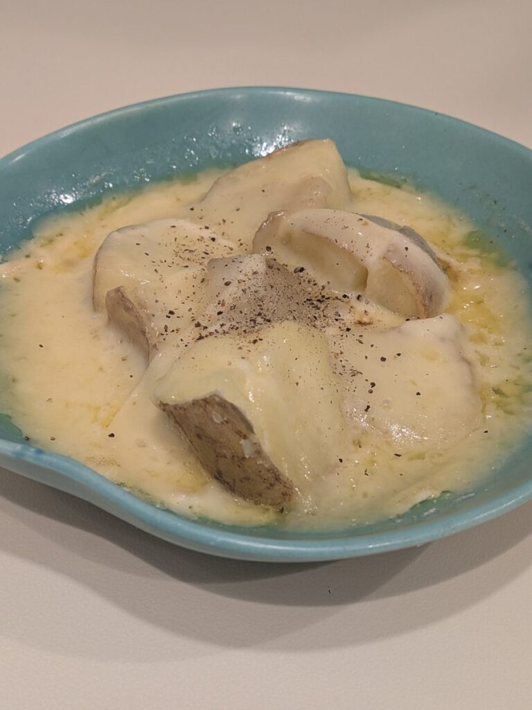 じゃがいもに溶けたラクレットチーズと黒こしょうをかけた一皿